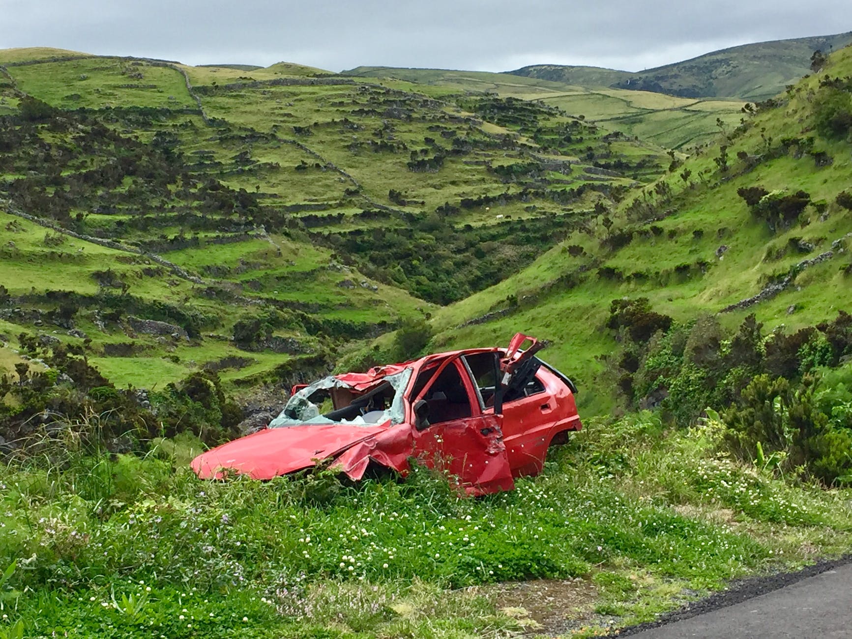 photo of broken red car on grass